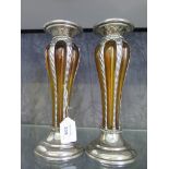 A pair of amber glass and white metal candle stands, of lobed form with pedestal foot, 25.5cm high