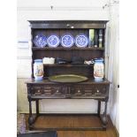 A late 17th century oak dresser and rack, the stepped two tier rack with later parts, over a dresser