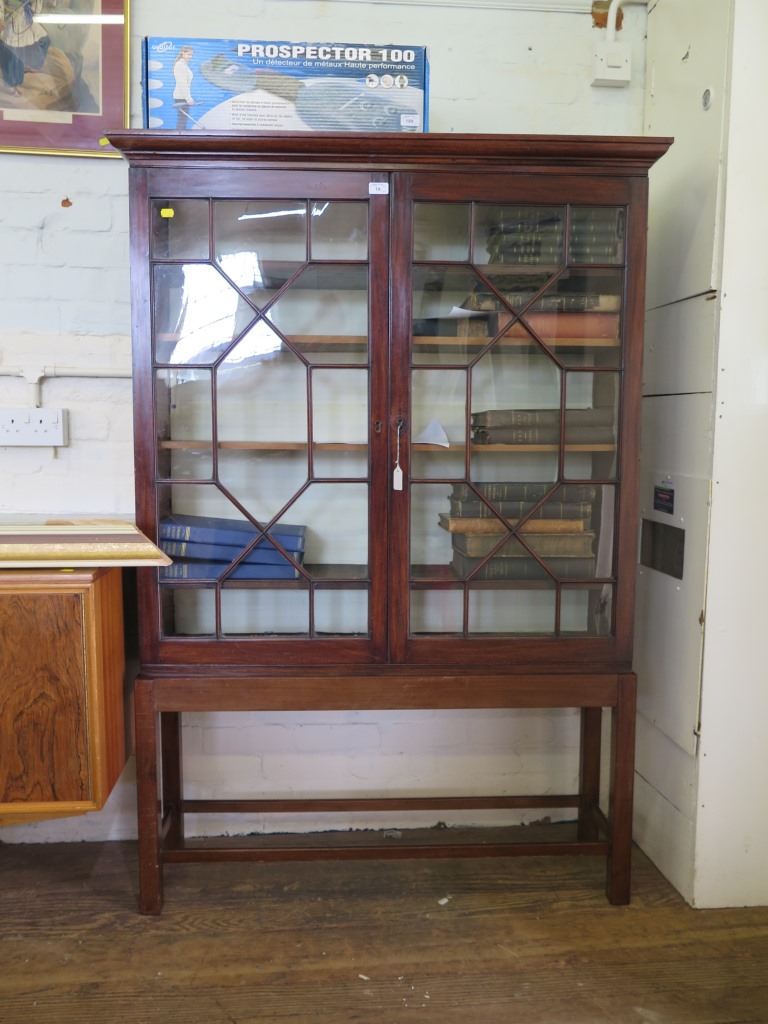 A mahogany bookcase on stand, the moulded cornice over a pair of astragal glazed doors, on a stand