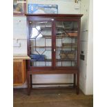 A mahogany bookcase on stand, the moulded cornice over a pair of astragal glazed doors, on a stand