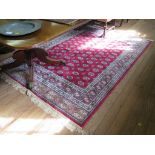 A Kashmir Bokhara style rug, the rows of guls on a red field within a multiple border 244cm x 155cm