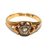 An 18 carat gold gypsy set ring set with an old cut diamond to the centre and a diamond at both