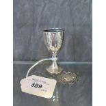A silver egg cup and a silver candlestick
