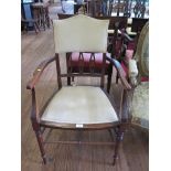 An Edwardian inlaid armchair, the shaped upholstered back over a padded seat on turned legs joined