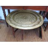 A large Moroccan brass top table, the circular top with geometric design over a turned and block