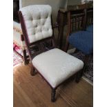 An Edwardian walnut fireside chair, with button upholstered and spindle back, stuffover seat and