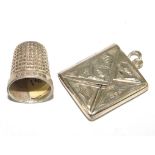 A silver stamp case and thimble