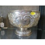 A silver punch bowl of circular form on domed foot, the embossed decoration with presentation