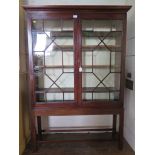 A mahogany bookcase on stand, the moulded cornice over a pair of astragal glazed doors, on a stand