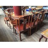 A Chinese hardwood dining table and eight chairs, with pierced carved splats and friezes,