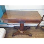 An early Victorian rosewood foldover card table, the frieze with acanthus carved panel on a turned