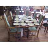 An Ercol dark oak extending dining table and six chairs, including two carvers on turned supports,