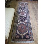 A Kazak runner, the ivory field with five red or black medallions within a geometric border, 290cm x