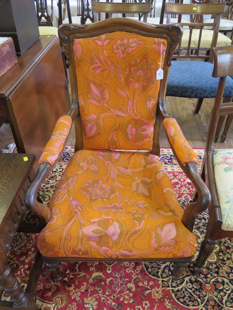 An early Victorian open armchair with upholstered back and seat on lotus carved legs