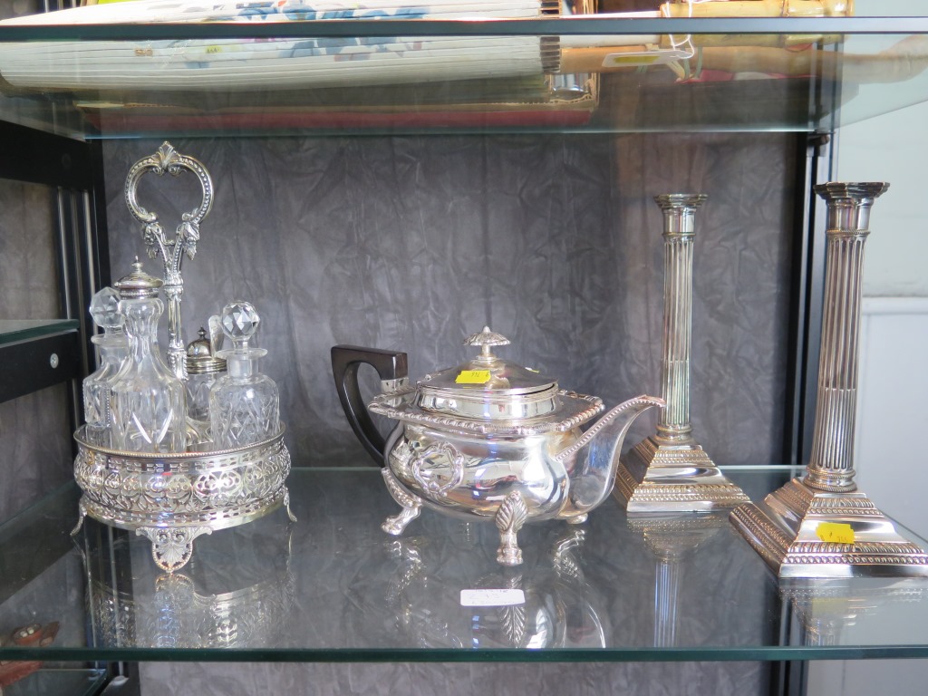 A silver plated tea pot, a pair of plated candlesticks and a plated cruet and a large plated tray