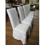 A set of six white upholstered dining chairs