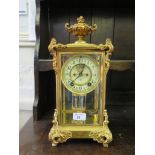 An early 20th century gilt brass Ansonia mantel clock, the urn finial over glazed sides with