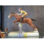 A Beswick figure of a girl riding a horse over a fence, 24.5cm high.