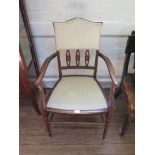 An Edwardian inlaid armchair, the shaped upholstered back over a padded seat on turned legs joined