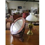 A Dutch inlaid oval table mirror 37.5cm high, a brass oil lamp