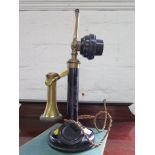 A blacked metal and brass stick telephone, as found