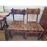 Two Victorian stained wood dining chairs, in the Gothic style, each with broad top rail