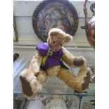 A long snouted Teddy Bear, wearing a purple waistcoat, with articulated limbs, 41cm long
