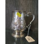 A Victorian silver tankard highly decorated in relief, London 1867, some engraving within the