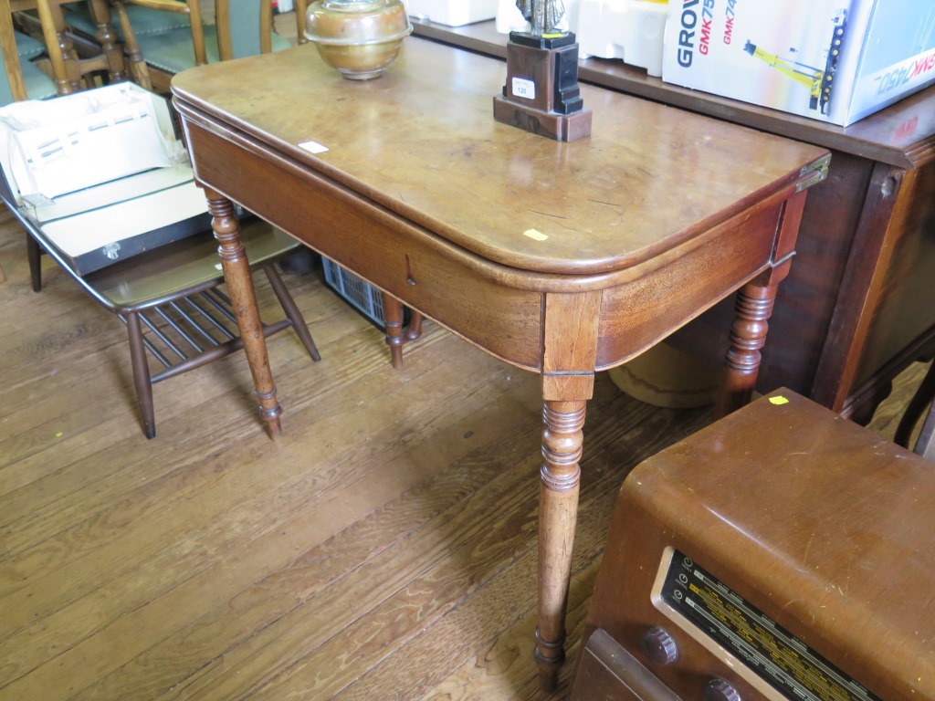 An early Victorian mahogany foldover tea table with broad frieze on ring turned tapering legs 91cm