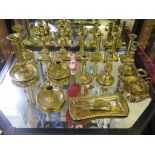 A set of four brass candlesticks, three pairs of brass candlesticks, four other candlesticks and a