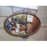 An oval giltwood wall mirror, with ribbon swags 78cm x 58cm