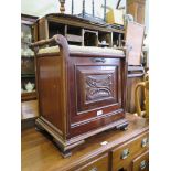 An Edwardian mahogany piano stool, the seat with turned handles over a carved fall front enclosing