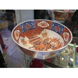 An Oriental bowl, with vases of flowers within red and blue panels, six character mark, 25cm