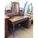 An Edwardian walnut dressing table, with swing mirror and trinket drawers over a long drawer and