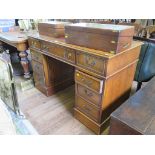 An oak pedestal desk, the leather inset top over three frieze drawers above pedestals, one with