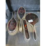 A ladies four piece silver and tortoiseshell brush and comb set