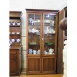 A mahogany glazed bookcase, with twin doors enclosing adjustable shelves, above a pair of panelled