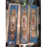 A set of three Sevres style doorplates, the pale blue grounds with floral decorated panels 32cm