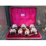 A presentation fitted case containing four silver salts and spoons, two silver peppers and a