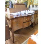 A George III style mahogany serpentine sideboard, the two central drawers flanked by cupboard