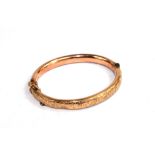 A 9 carat gold bangle with chased decoration