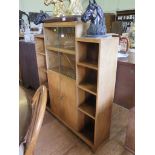 A 1930s walnut bookcase cabinet, the stepped top with twin sliding glazed shelves over cupboard