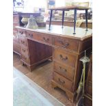 A reproduction yewwood pedestal desk, the leather inset top over three drawers and pedestals, one