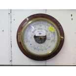 A Kelvin Hughes circular wall barometer with mahogany mount, silver dial and thermometer 21cm