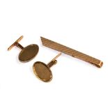 A gold tie pin and cufflinks