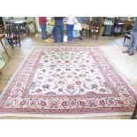 A Persian style carpet, the ivory field with all over design of palmettes and foliage within a