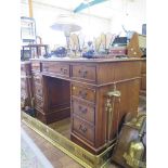 An oak pedestal desk, the leather inset top over three frieze drawers above pedestals, one with