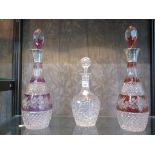 A pair of Bohemian cut glass decanters, cut with floral decoration in red and purple bands, with