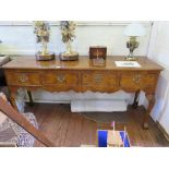 A reproduction George I style burr walnut dresser, with four short drawers on shell carved