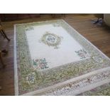 An European wool carpet, the ivory field with rose spray centre and spandrels within a green foliate
